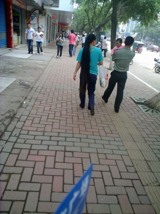 Streetshot of long ponytail by mobilephone in Labour Day