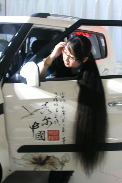 A girl show her long hair beside car