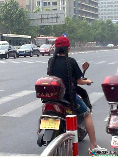 Streetshot of long braid girl drive moto