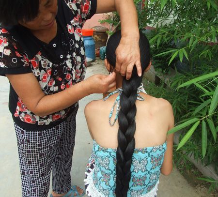 Old woman made long braid for young girl