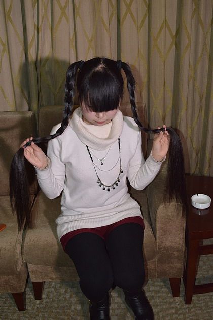 Young girl play with her long hair