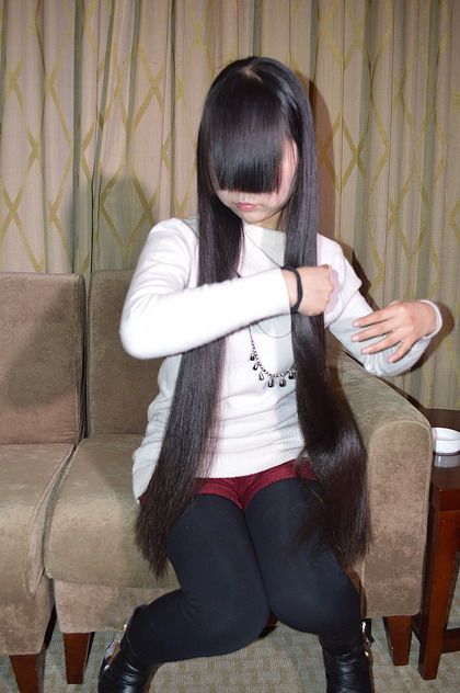 Young girl play with her long hair
