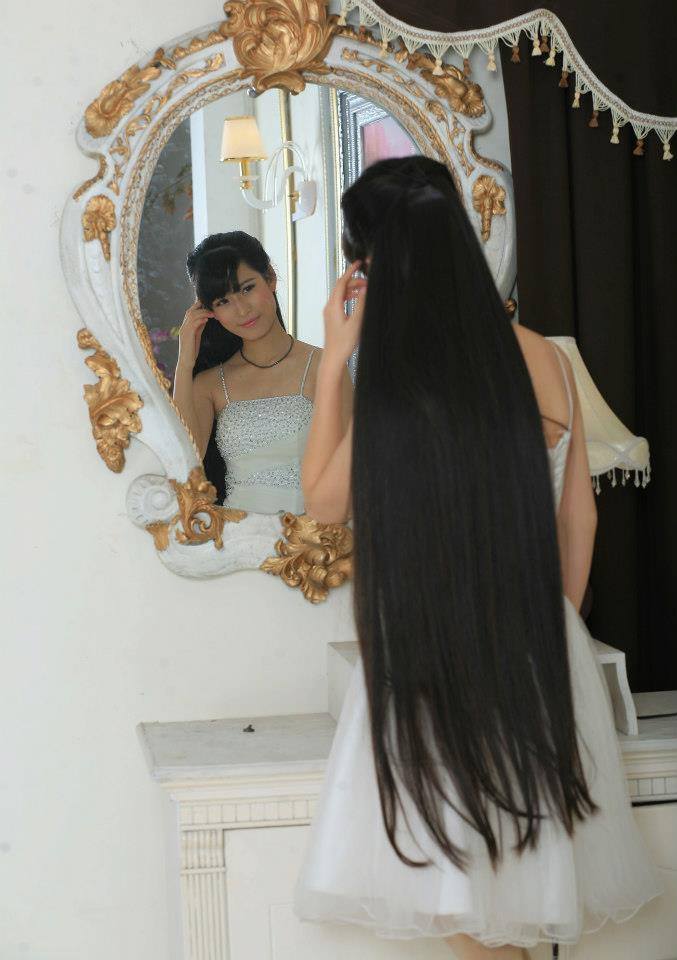 Long hair girl pat her bangs in front of mirror