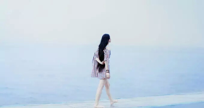 Long hair girl wandered beside sea 