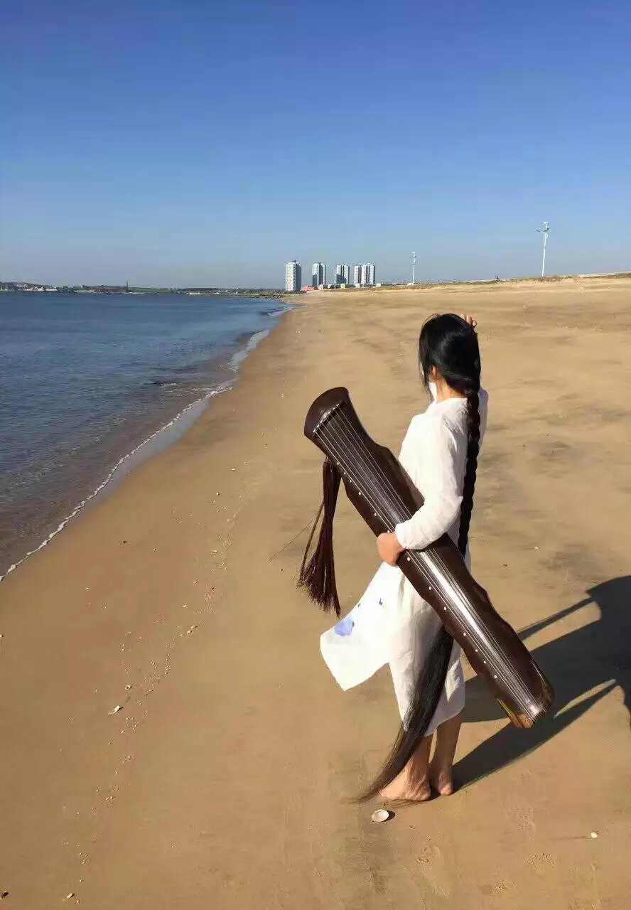 Super long hair play instrument on beach