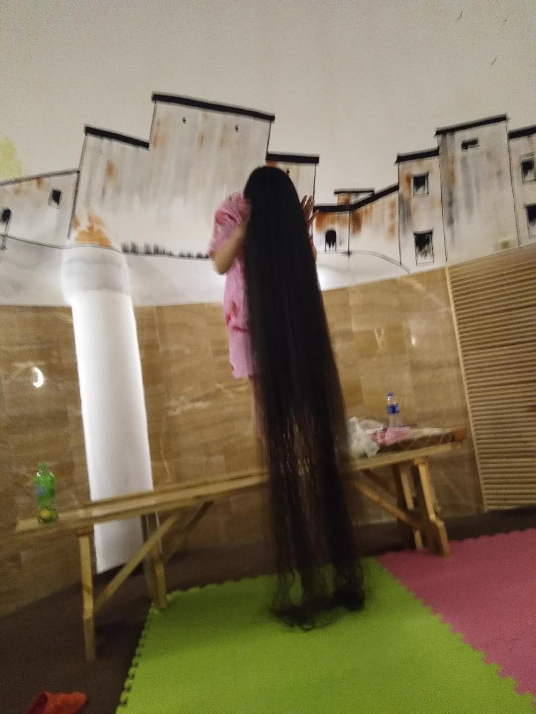 She stands on table with long hair drag on ground