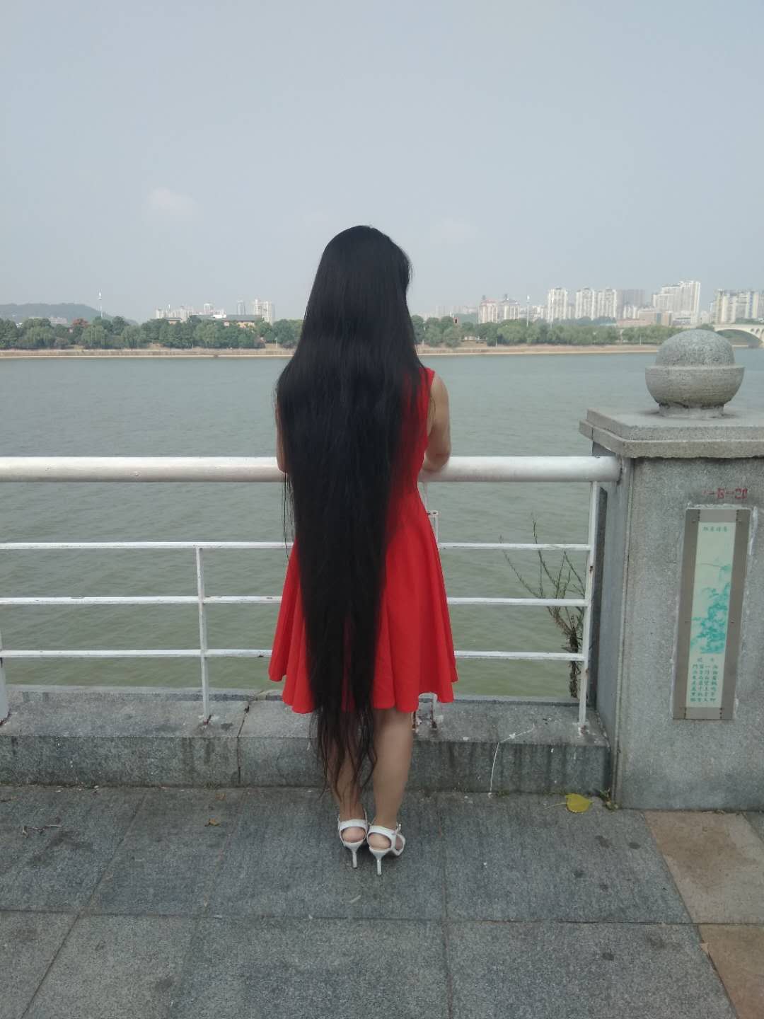 Calf length long hair with red skirt near river